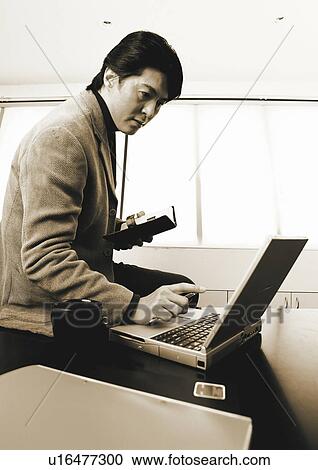 Stock Image - sepia, asian ethnicity, well dressed, business in asia, sitting, formal. Fotosearch