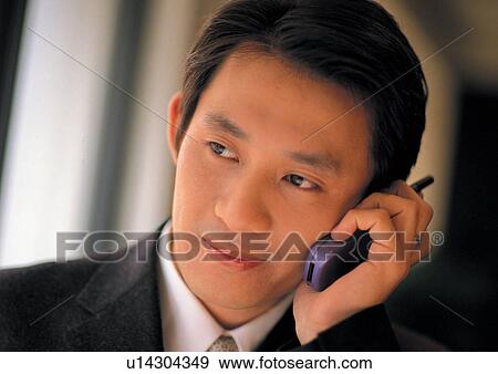 Stock Photo - well dressed, business in asia, on the phone, asian ethnicity. Fotosearch