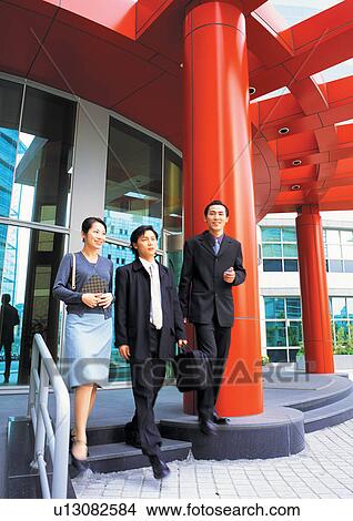 Picture - well dressed, business people, suit, smiling, building exterior. Fotosearch