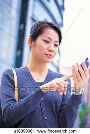Stock Image - well-dressed, communication, on the phone, asian ethnicity. Fotosearch