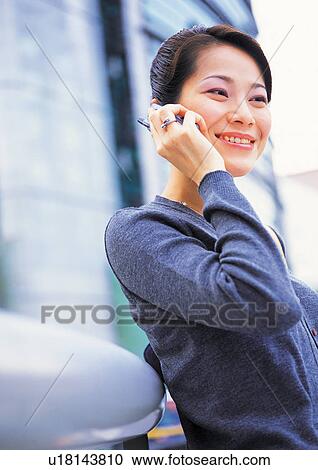 Stock Image - well-dressed, communication, on the phone, asian ethnicity. Fotosearch