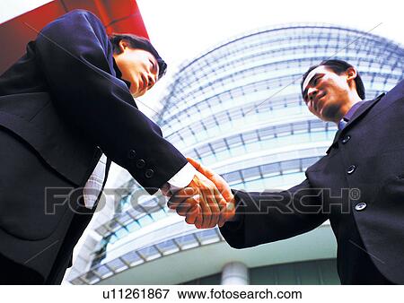 Stock Photo - well dressed, talking, business in asia, asian ethnicity. Fotosearch