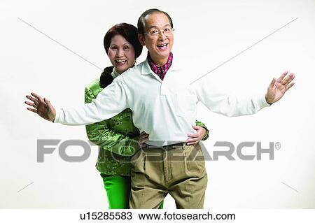 Stock Image - Brown Hair, Arm Outstretched, Belt, Balding, Asian Ethnicity, Adults Only. Fotosearch