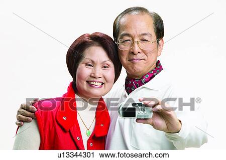 Stock Image - Mature Men, Digital Camera, Eyeglasses, Asian Ethnicity, Adults Only. Fotosearch