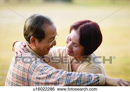 Stock Photograph - Arm Around, Button Down Shirt, Brown Hair, Asian Ethnicity, Adults Only. Fotosearch