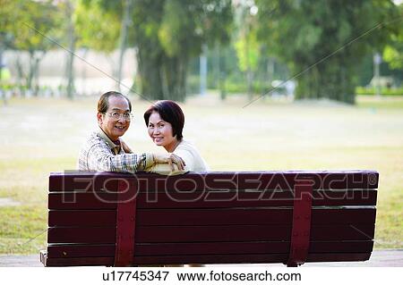 Asian Ethnicity, Button Down Shirt, Brown Hair, Bench, Adults Only View Large Photo Image Stock Photo - Asian Ethnicity, Button Down Shirt, Brown Hair, Bench, Adults Only. Fotosearch