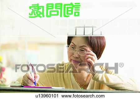 Stock Image - Brown Hair, Checkout Counter, Businesswoman, Business Suit, Asian Ethnicity. Fotosearch