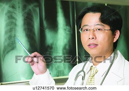 Holding, Male Doctor, Looking Away, Doctor, One Young Man Only View Large Photo Image Stock Image - Holding, Male Doctor, Looking Away, Doctor, One Young Man Only. Fotosearch