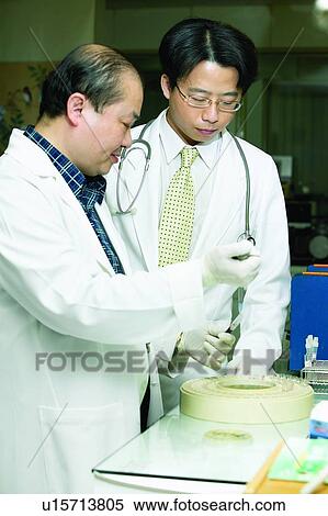 Stock Photography - Receding Hairline, Surgical Glove, Young Men, Eyeglasses, Scientist, Looking Down. Fotosearch