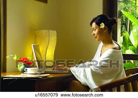 Stock Photo - Asian Ethnicity, Brown Hair, Bathrobe, Armchair. Fotosearch