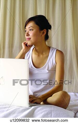 Stock Image - Bed, Brown Hair, Bedroom, Asian Ethnicity. Fotosearch