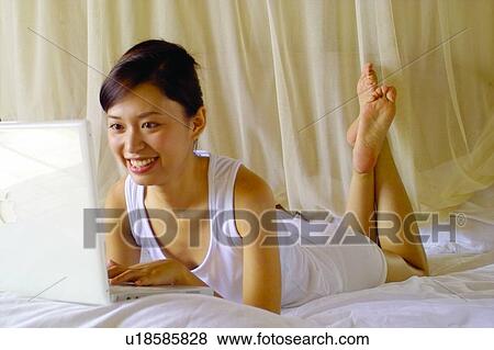 Cheerful, Barefoot, Brown Hair, Bedroom, Bed, Asian Ethnicity View Large Photo Image Stock Photo - Cheerful, Barefoot, Brown Hair, Bedroom, Bed, Asian Ethnicity. Fotosearch