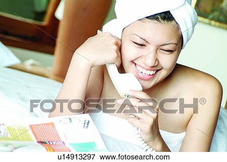 Stock Photo - Lying On Front, Indoor, Close-Up, On The Phone, Tilt, Relaxation, Comfort. Fotosearch