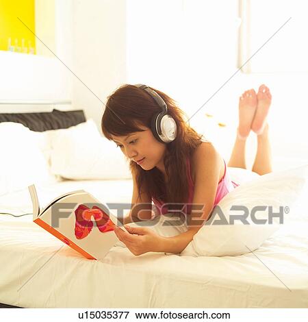 Stock Photo - Barefoot, Book, Bedroom, Bed, Asian Ethnicity. Fotosearch