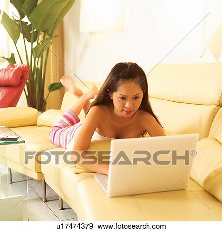 Stock Photo - Casual Clothing, One Person, Day, Teenage Girl, Lying On Front, Asian Ethnicity. Fotosearch