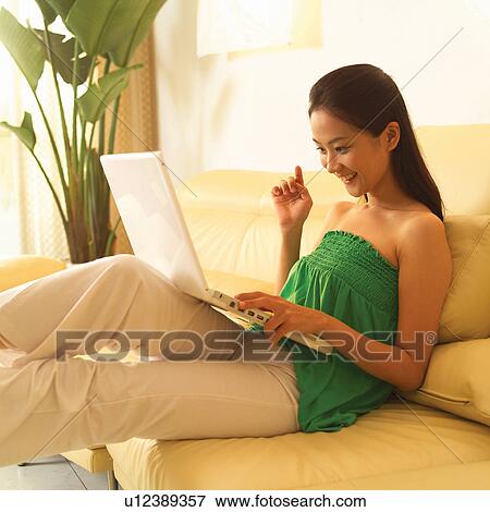 Stock Photo - Day, Toothy Smile, Couch, Home Interior, Fun, Female. Fotosearch