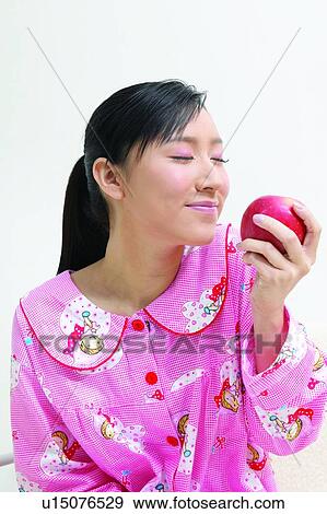 Stock Photo - Asian Ethnicity, Close-Up, Black Hair, Apple. Fotosearch