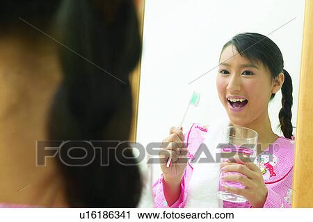 Stock Image - Close-Up, Bathroom, Brushing, Braids, Black Hair, Asian Ethnicity. Fotosearch