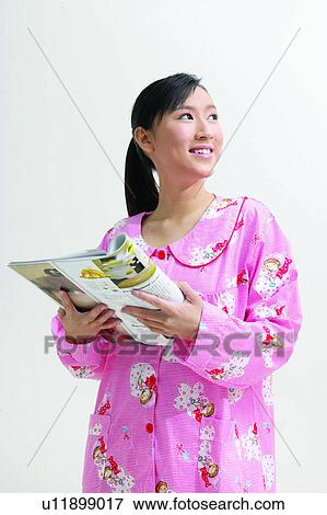 Stock Photo - Smiling, Nightwear, Magazine, Looking Up. Fotosearch