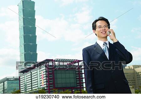 Stock Image - Building Exterior, Looking Away, Wireless Technology, Mobility, Cheerful. Fotosearch