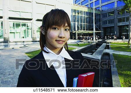 Stock Image - Business Suit, Bangs, Building Structure, Building Exterior, Brown Hair, Asian Ethnicity. Fotosearch