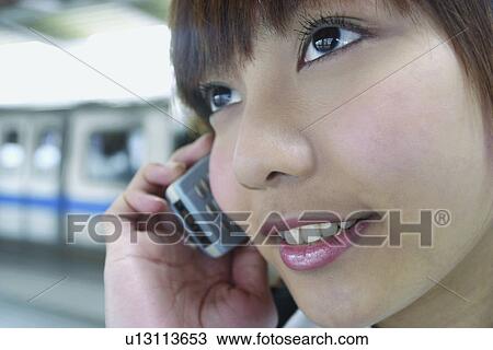 Stock Image - Focus On Foreground, Wireless Technology, Listening, Holding, Office Lady, Asian Ethnicity. Fotosearch