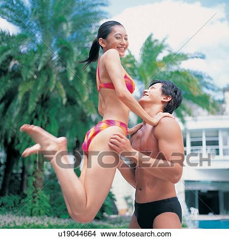 Holding, Waist-Up, Asian, Medium-Length Hair, Swimming Trunks, Young Couple View Large Photo Image Picture - Holding, Waist-Up, Asian, Medium-Length Hair, Swimming Trunks, Young Couple. Fotosearch