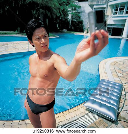 Stock Photograph - One Person, Day, Asian, Relaxation, Camera, Pool Raft, Technology. Fotosearch