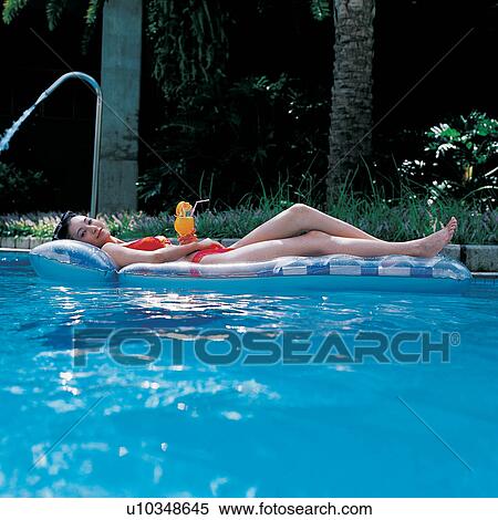 Stock Photography - Swimsuit, Glass, Straw, Outdoor, Hand On Hip, Carefree. Fotosearch