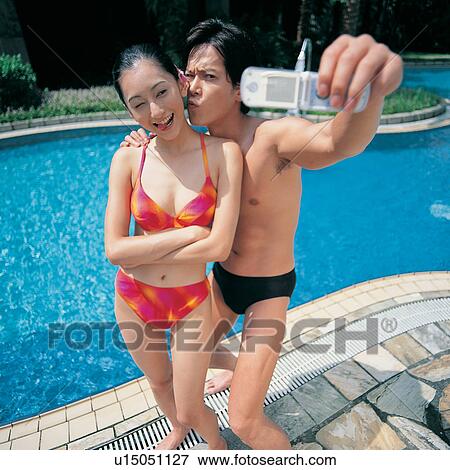 Stock Photo - Technology, Hand Raised, Smiling, Swimsuit, Summer, Square, Poolside. Fotosearch
