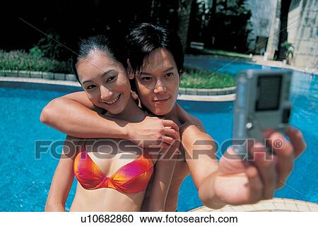 Stock Image - Young Couple, Outdoor, Love, Asian Ethnicity, Arm Around, Holding. Fotosearch
