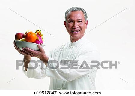 Stock Photo - Indoor, Asian Ethnicity, Close-Up, One Mature Man Only, Portrait, Tai-Chi Active, White Background. Fotosearch