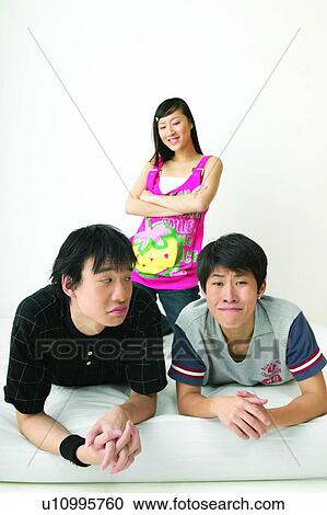 Stock Image - Black Hair, Adolescence, Bed, Asian Ethnicity, Arms Crossed, Casual Clothing, 16-17 Years. Fotosearch