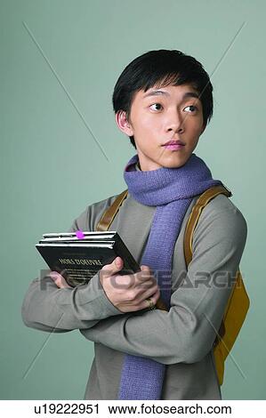 Stock Image - Book, Adolescence, Black Hair, Backpack, Asian Ethnicity, Casual Clothing, 16-17 Years. Fotosearch
