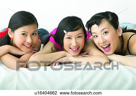 Stock Image - Braids, Adolescence, Black Hair, Bed, Asian Ethnicity, Casual Clothing, 16-17 Years. Fotosearch