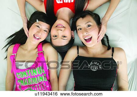 Stock Photograph - Casual Clothing, Adolescence, Black Hair, Bed, Asian Ethnicity, Close-Up, 16-17 Years. Fotosearch