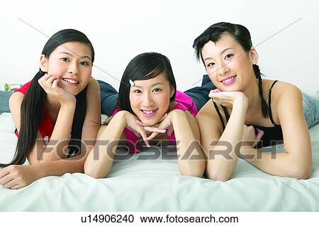 Stock Image - Casual Clothing, Black Hair, Looking At Camera, Hand On Chin, Tank Top, Hair Clip, Waist-Up. Fotosearch