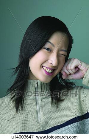 Stock Photo - Colored Background, Eastern, Mischief, Winking, Toothy Smile, Long Hair. Fotosearch