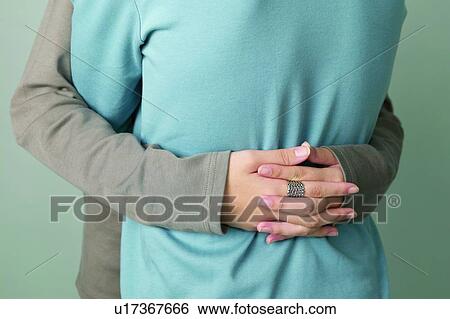 Stock Photograph - Eastern, Rear View, Affectionate, 16-17 Years, Colored Background, Indoor. Fotosearch
