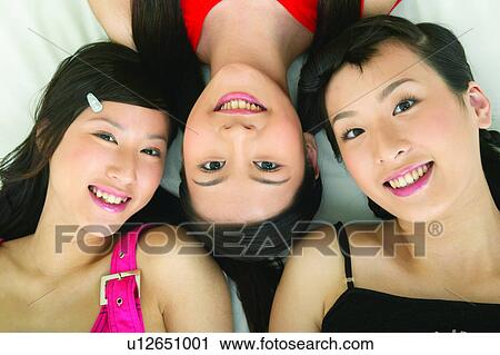 Stock Image - Leisure Activity, Togetherness, Looking At Camera, Long Hair, Teenagers, Lying Down. Fotosearch
