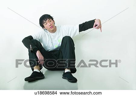 Picture - Lifestyles, Eastern Hand On Knee, Black Hair, Serious, Leaning, Sitting. Fotosearch