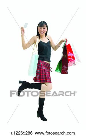 Stock Photograph - Shopping, Smiling, Indoor, Shopping Bag, Standing On One Leg, Lifestyles. Fotosearch