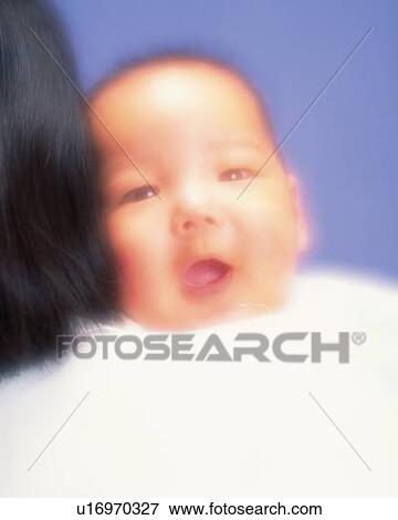 Baby boy smiling on mother's shoulder, defocused, portrait View Large Photo Image Stock Photo - Baby boy smiling on mother's shoulder, defocused, portrait. Fotosearch