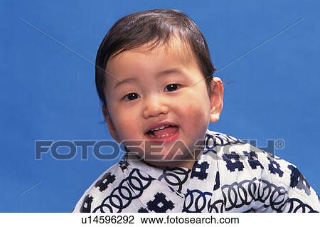 Stock Image - Baby boy wearing yukata, smiling, front view, portrait. Fotosearch