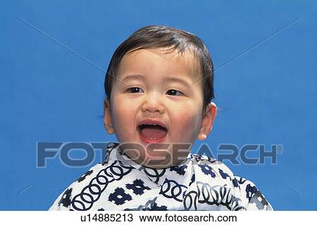 Stock Image - Baby boy wearing yukata, smiling, front view, portrait. Fotosearch