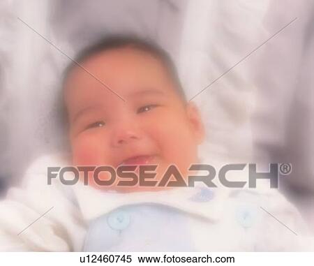Stock Photography - Close up of baby boy with mother, portrait, high angle view, defocused. Fotosearch