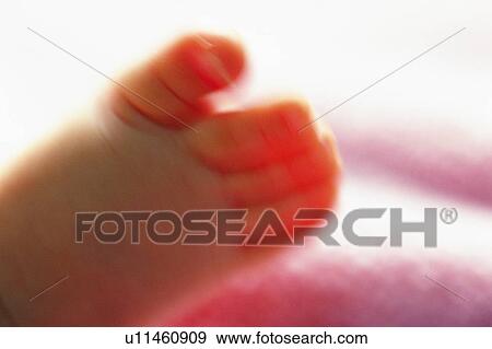 Stock Photo - Close up of baby's foot, front view, Blurred Motion . Fotosearch