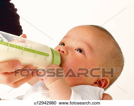 Stock Image - Mother feeding baby boy, portrait, side view. Fotosearch