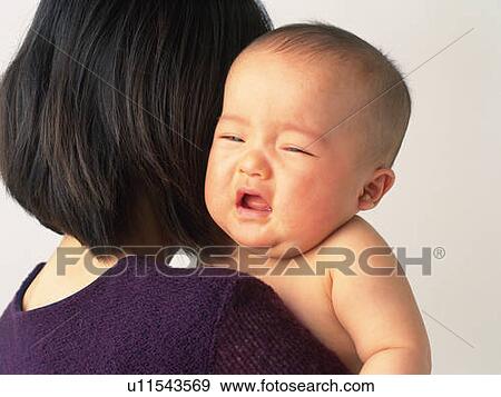 Mother holding baby boy, baby crying, portrait, side view View Large Photo Image Stock Photo - Mother holding baby boy, baby crying, portrait, side view. Fotosearch