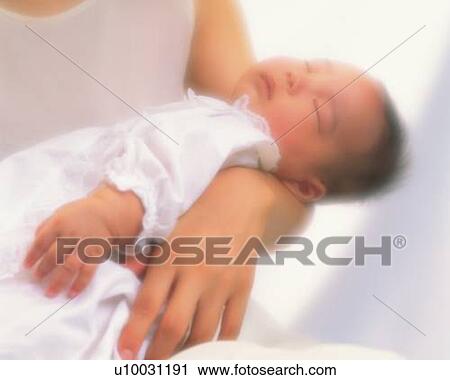 Stock Image - Mother holding baby boy, portrait, high angle view, Differential Focus. Fotosearch